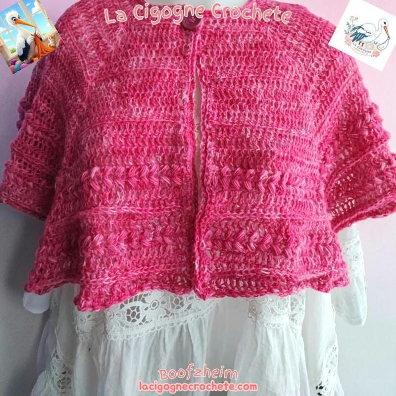 Cape chauffe-épaules rose au crochet modèle 4, bandes en relief et bouton visible, vue entière de devant